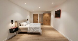 A modern bedroom with a bed, bedside table, and a wardrobe. - BASE Achensee Energy No5 – Terrace with a daybed (Achenkirch)
