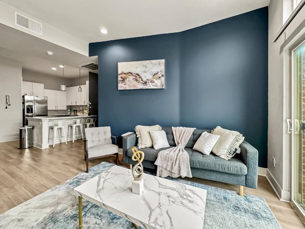 Een moderne woonkamer met een bank, salontafel en kunst aan de muur.