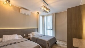 A hotel room with two beds, a wooden wardrobe, a ceiling light fixture, and a window with curtains. - Sodic Eastown  Panoramic EDNC View + Monorail (Cairo Governorate)