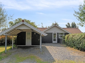 Two small, single-story buildings with attached porches, a gravel driveway, and a red-tiled roof. - 4 Star Holiday Home in Rodby (Rodby)
