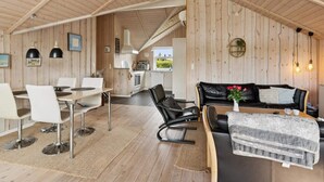 En modern inredning med ett matområde, en soffa och ett kök.