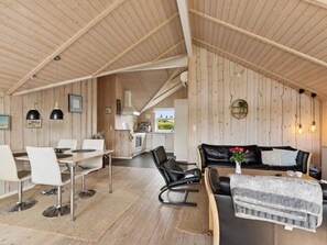 Ein modernes Interieur mit Essbereich, einer Couch und einer Küche.