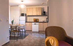 A compact kitchen with a microwave, refrigerator, and dishwasher. There is a dining area with a table and chairs. - Spacious Six-guest Fabregues Retreat (Fabregues)