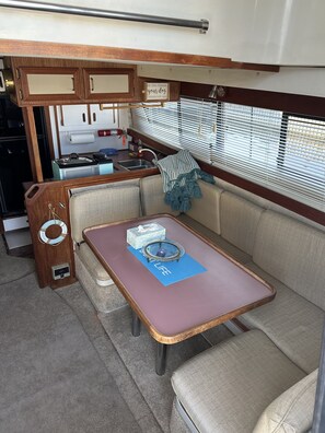A compact RV interior with a kitchenette, a dining area, and a seating space.