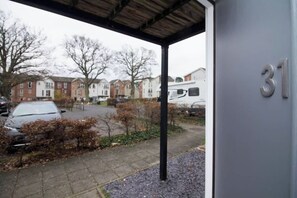 A residential area with a house number 31, a covered porch, and a parked camper van. - Beautiful 4 Bedroom House Berkshire - Free Parking (Bracknell)