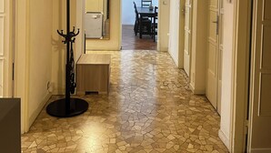 A hallway with a tiled floor, a coat rack, a dining area with chairs and a table, and a painting on the wall. - Penthouse 200 sqm 5 min walk from Duomo Milano cathedral. Vip Are sleeps 10 max (Milano)