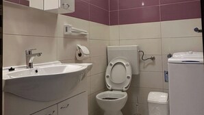 Ein Badezimmer mit Waschbecken, Toilette und Spiegel.