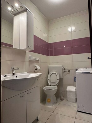 Ein Badezimmer mit Waschbecken, Toilette und Spiegel.