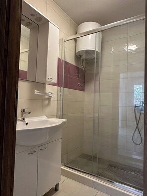 A bathroom with a glass-enclosed shower, a white sink, and a mirror above the sink. - 2-bedroom apartment in peaceful Sevid na moru with AC (Sevid na moru)