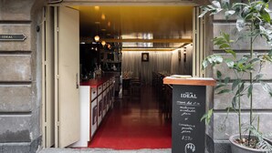 A restaurant interior with a red carpet, wooden counter, and a chalkboard menu. - Casa Bosques Pensión (Mexico City)