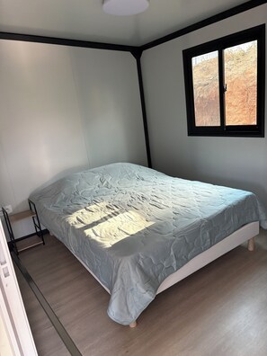 A bedroom with a bed, a window, and a wooden floor. - New: Enjoy a peaceful vacation in Corsica (Tavaco)
