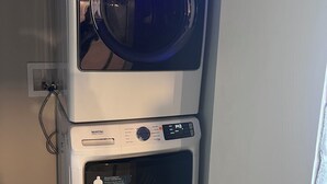 A stacked washer and dryer unit with a control panel and a digital display. - Spacious 5-bedroom apartment (Worcester)