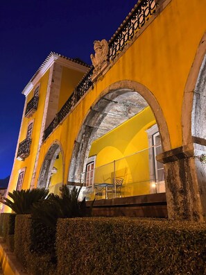 A yellow building with arched windows and a balcony with chairs. - Arcos House by the Sea, 1 bedroom Apt Sleeps 4 (Paço de Arcos)