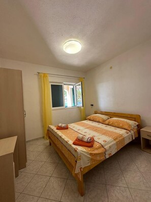 A bedroom with a bed, a window, a door, and a bedside table. - 2-bedroom apartment in fabulous Sevid na moru with AC (Sevid na moru)