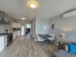 Un appartement moderne comprenant une cuisine, un coin repas et un salon.