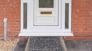 A white door with a glass panel, a brass doorknob, and a small brass plate above the door. - Modern 5 Bed Fully Detached Guest House (with parking) (Walsall)