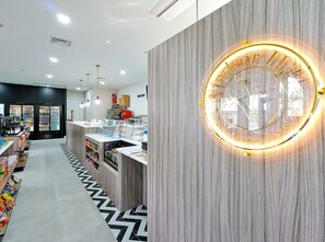 Ein modernes Interieur mit einem beleuchteten Rundschild, Verkaufsautomaten und einem gemusterten Boden.