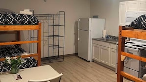 Une cuisine compacte équipée d’un réfrigérateur, d’une cuisinière et d’un coin repas avec une table et des chaises.