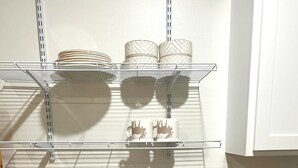 Une cuisine dotée d’un évier en acier inoxydable, de meubles blancs et d’un plan de travail.