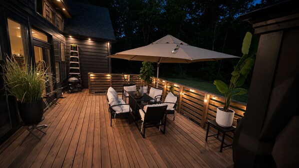 A wooden deck with outdoor furniture, a table, and an umbrella. - Ultra-Luxury Estate Private Gated Entry, Spa & Concierge from-Airport and games (Douglasville)