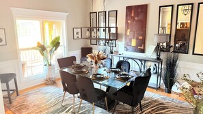 A dining area with a glass table, black chairs, and a decorative centerpiece. - Ultra-Luxury Estate Private Gated Entry, Spa & Concierge from-Airport and games (Douglasville)