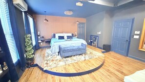 A bedroom with a bed, bedside tables, a desk, a chair, a small plant, and a door. - Ultra-Luxury Estate Private Gated Entry, Spa & Concierge from-Airport and games (Douglasville)