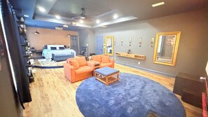 Ein Zimmer mit einem Bett, zwei Sofas, einem kleinen Tisch und einem blauen Teppich.