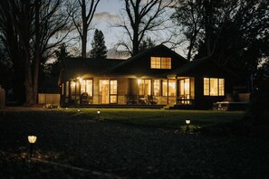 A house with a porch, large windows, and a chimney.