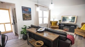 Uma sala de estar com sofá, mesa de centro, lareira e televisão.