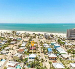 An aerial view of a coastal resort with multiple buildings, a beach, and a clear view of the ocean. - Beach Time  - Elevator - Pool - 3 Min to Beach (Fort Myers Beach)