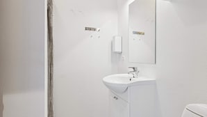 Ein Badezimmer mit Waschbecken, Spiegel und Duschvorhang.