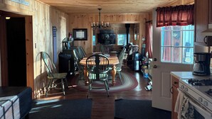Ein Holzblockhaus-Interieur mit Essbereich, Küche und einem Schild, das auf einen Seeurlaub hinweist.