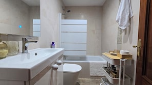 Ein Badezimmer mit Waschbecken, Toilette, Dusche und Handtuchhalter.