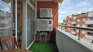 Ein Balkon mit einer Mitsubishi Electric Klimaanlage, einem Haier Inverter und einer kleinen Pflanze.