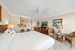 A hotel room with a bed, a ceiling fan, a dining area, and a television. - Direct Oceanfront Studio with Lanai & Sunset Views -Lahaina Shores 331 (Lahaina)