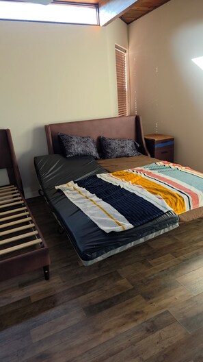 A bedroom with a bed, a wooden bench, a nightstand, and a window with blinds. - Spacious 6-bedroom 4 toilets house in Houston Texas  available for short rent (Houston)