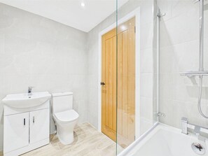 Un baño con inodoro, lavamanos y ducha.