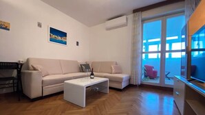 A living room with a sofa, coffee table, and a TV. - 2BR Sea View | 3 ACs | Žnjan Walk (Split)