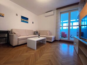 Ein Wohnzimmer mit einer Couch, einem Couchtisch und einem Fernseher.