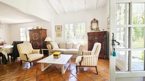 A living room with a wooden coffee table, striped armchairs, a sofa, and a cabinet. - Charming Provençal villa with a pool and sauna (MONTFERRAT)