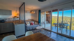 Eine moderne Küche mit Essbereich, einer Couch und einem Balkon mit Blick.
