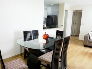 A dining area with a glass table, black chairs, and a red decorative item. - Your Furnished Apartment on Pardo Avenue, Miraflores, Lima – Excellent Location (Miraflores)
