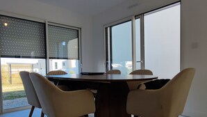 A dining area with a table, chairs, and large windows. - Quiet house just 5 minutes from the beaches with direct access to the bike path  (Clohars-Carnoët)