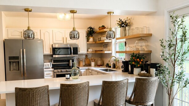 A modern kitchen with a central island, bar stools, a refrigerator, microwave, oven, and hanging pendant lights. - The Willow-A Seabrook Coastal Retreat Near Beaufort & Hunting Island (Seabrook)