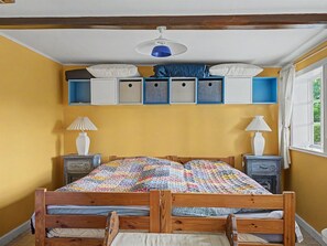 A bedroom with a wooden bed, two bedside tables, a ceiling fan, and built-in storage cabinets. - "Sida" - 1.3km from the sea by Interhome (Tranekær)