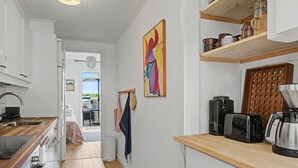 Une cuisine avec un plan de travail en bois, une machine à café et un grille-pain.