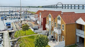 Un port de plaisance avec des bateaux, un pont en arrière-plan et des bâtiments en bois dotés de balcons.