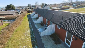 Une rangée de maisons mitoyennes avec un trottoir pavé et un petit ruisseau.