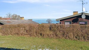 Une maison située sur la côte, dotée d’une antenne parabolique, d’un garage et offrant une vue sur la mer.