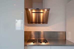 Una campana extractora de acero inoxidable con dos luces, un horno doble y un protector contra salpicaduras de acero inoxidable.